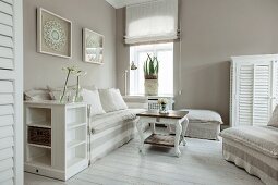 Sofa and armchair with white and pale grey striped loose covers in corner of bright living room with maritime ambiance