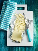 White chocolate in silver foil on a chopping board