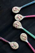 Colourful spoons covered with white chocolate and bright hundreds and thousands
