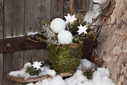 Planter wrapped in moss and decorated with baubles and stars