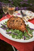Leg of lamb with lavender and garlic on a table outside