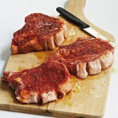 Marinated pork chops on a wooden chopping board