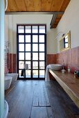Rustikales Badezimmer mit altem Holzboden und Sprossenfenster