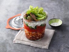 Layered pepper and bean salad with feta cheese in a jar