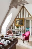 Pink armchair and gilt-framed painting in attic lounge