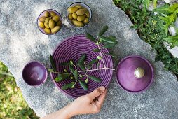 Olives and an olive sprig on a plate on a stone platter (Italy)