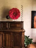 Red juju hat on top of antique wooden cabinet