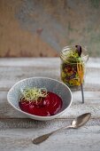 Cremige Rote-Bete-Kokos-Suppe mit Zwiebelsprossen und Salat im Glas