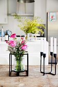Blumenstrauss in Glasvase mit Metallgestell und Kerzenhalter aus schwarzem Metall
