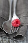 A raspberry on silver cutlery
