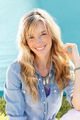 A young blonde woman wearing a denim shirt