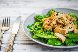 Grilled chicken with spinach, rocket and peas