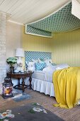 Bed with valance and canopy against yellow board wall