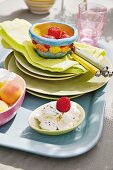 Cream cheese and fresh fruit in a bowl and on a plate on a tray