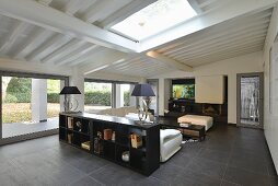 Modern, black and white living room with glass wall under sloping ceiling