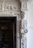 Detail of fireplace with ornate stucco elements and bust