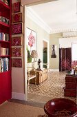 Open doorway leading into artistic living room with old suitcases used as side table and cement floor tiles