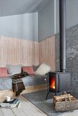 Fireplace in comfortable living area of old wooden house with high sloping ceiling