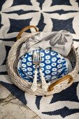 Blue and white crockery on wicker tray on patterned rug
