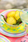 Lemons in bowl on colourful plate