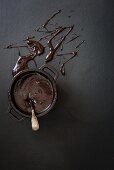 A bowl of melted chocolate on a grey surface
