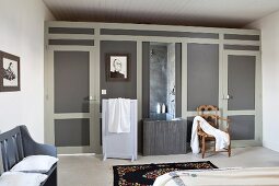Schlafzimmer mit eingebautem Duschbereich in elegant gestaltete Raumteilerwand