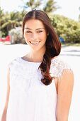 A young brunette woman wearing a white top