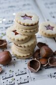 Jam sandwich biscuits with hazelnuts on a piece of sheet music