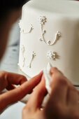 A confectioner decorating a wedding cake