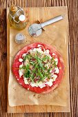 Red pizza with sheep cheese, rocket and red onions