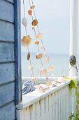 Muschelgirlanden an einer Holzhütte am Meer