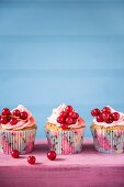 Cupcakes with pink butter cream and redcurrants