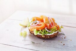 Half a wholemeal roll topped with smoked salmon, lettuce, onions and creamy horseradish