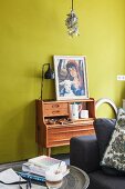 Picture on top of retro writing desk against mustard-yellow wall