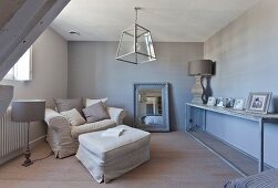 Armchair with ottoman and long console table in monochrome room