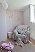 Throw on armchair below stars on wall in child's bedroom