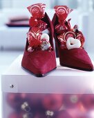 Dark red suede ladies' shoes filled with Chocolate Father Christmases and sweets