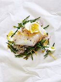 Cod on parchment paper with seaweed, fennel and lemon