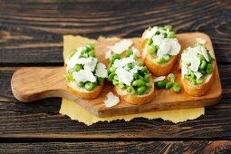 Bruschetta topped with green peas and Parmesan cheese
