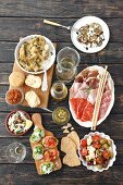 A selection of antipasti (artichokes, arancini, a cold cuts platter, courgette, pesto, bruschetta, seafood salad, tomato and mozzarella salad, Italy)