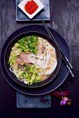 Udonnudel-Suppe mit Schweinefleisch, Pak Choi, Frühlingszwiebeln und Sesam (Japan)