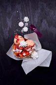 Peach and strawberry ice cream in waffles with fresh and freeze-dried strawberries and meringue