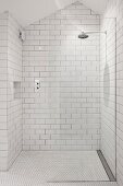 White-tiled shower area with rainfall shower in attic bathroom