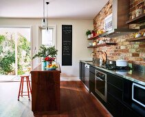 Kitchen with brick wall, kitchen island and wooden floor