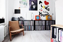 Wohnbereich mit kaputtem Retro Sessel vor Schallplattensammlung in schwarzen Regalmodulen