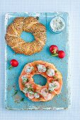 A bagel topped with smoked salmon, capers, radishes and dill sauce