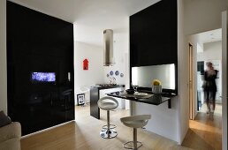 Black partition with integrated TV and partition with fold-up glossy table