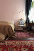 Baroque armchair and various rugs in bedroom