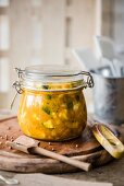A jar of piccalilli with a wooden spoon