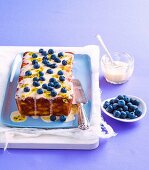 Joghurtkuchen mit Ananas, Passionsfrucht, Zuckerglasur und Blaubeeren